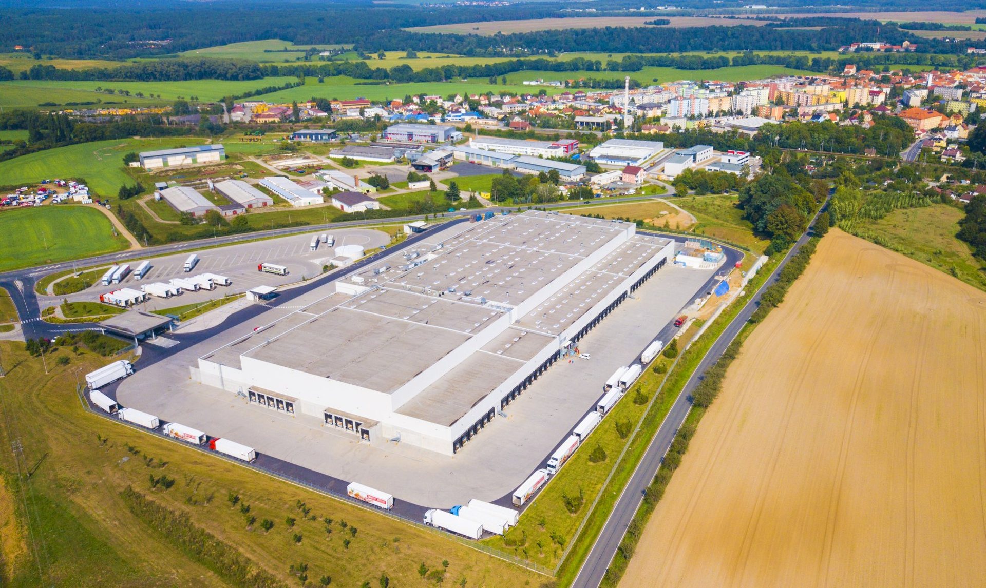 Aerial,View,Of,Modern,Storage,Warehouse,With,Many,Trucks,On